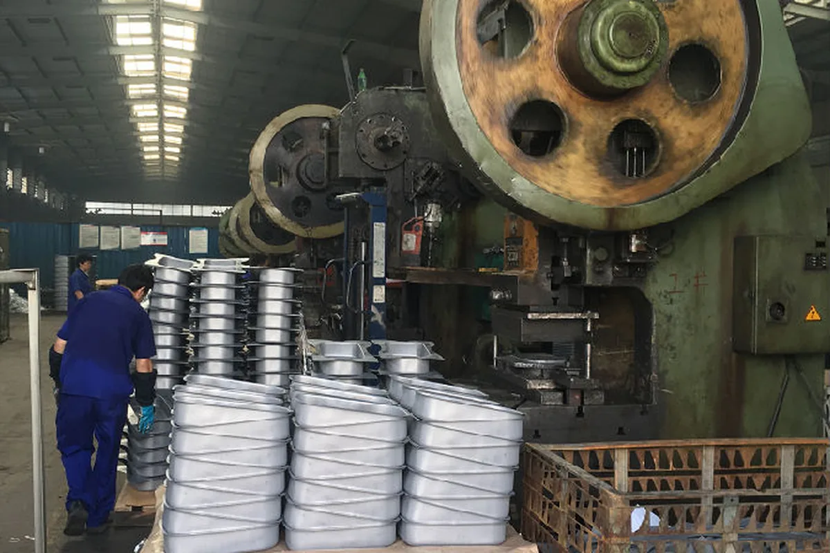 Steel jerry can shells stacked at the flywheel press line in the Fortitude21 plant