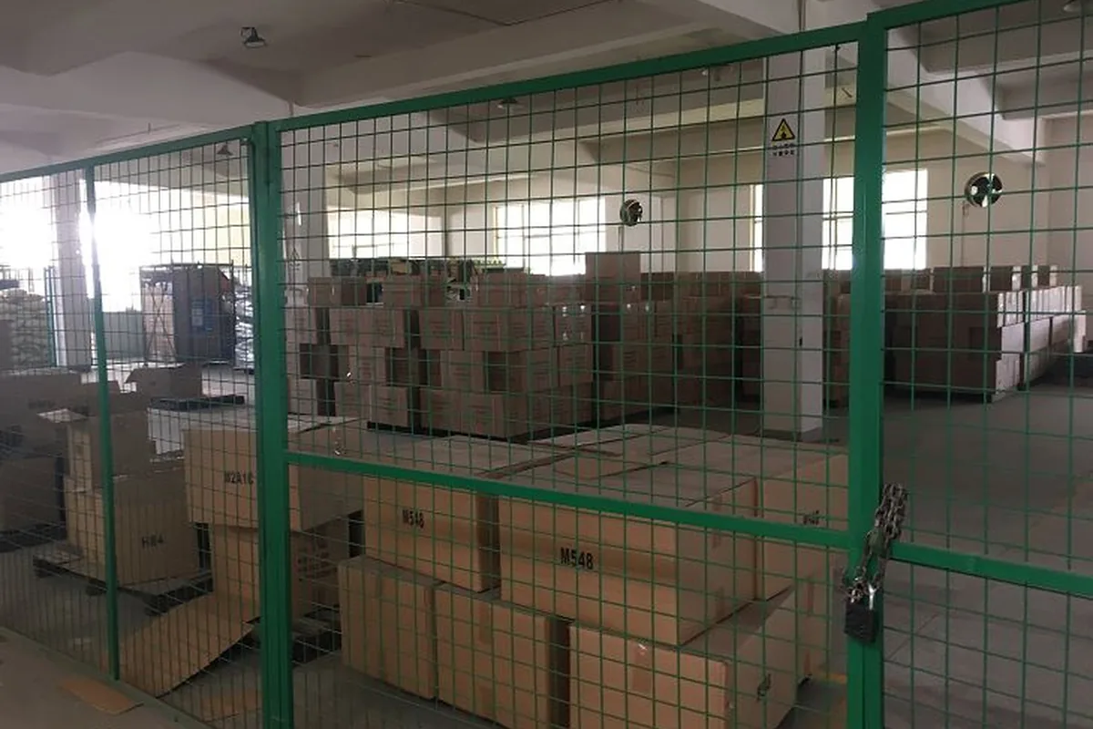 Cartoned cans staged behind a security cage in the Fortitude21 warehouse, ready for dispatch
